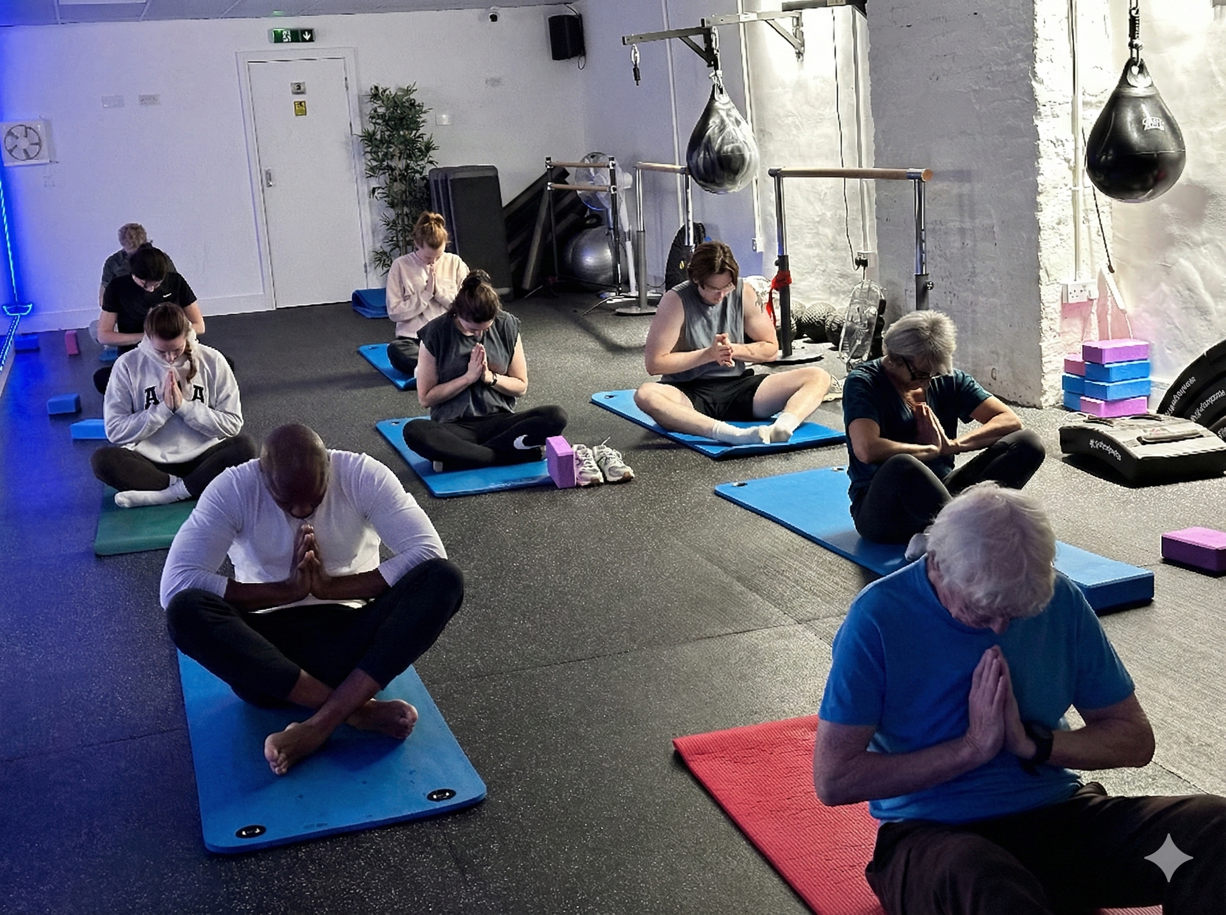Yoga class in seated meditation with prayer hands
